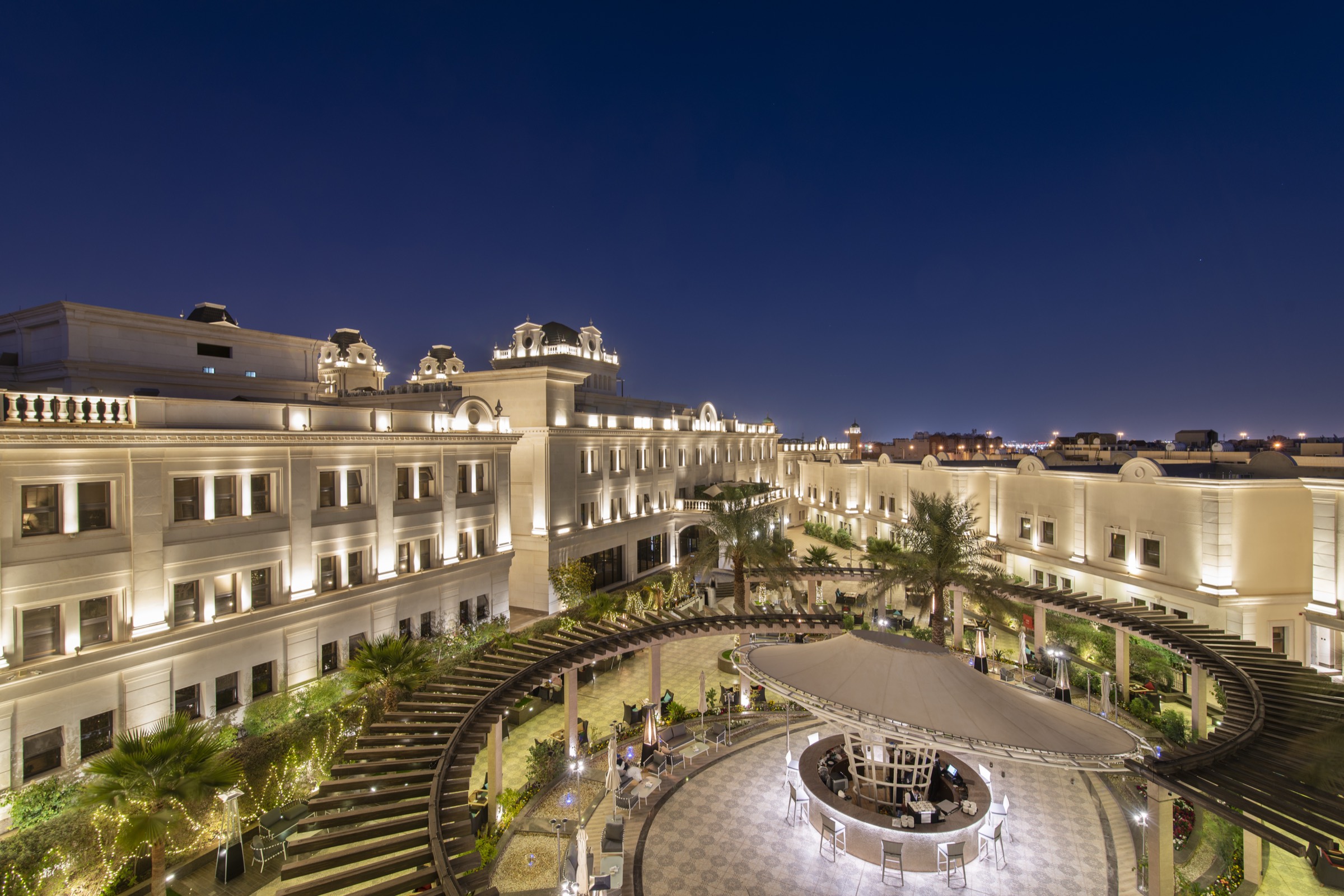 Vittori Palace at blue hour, its lit facade wrapping the courtyard gardens
